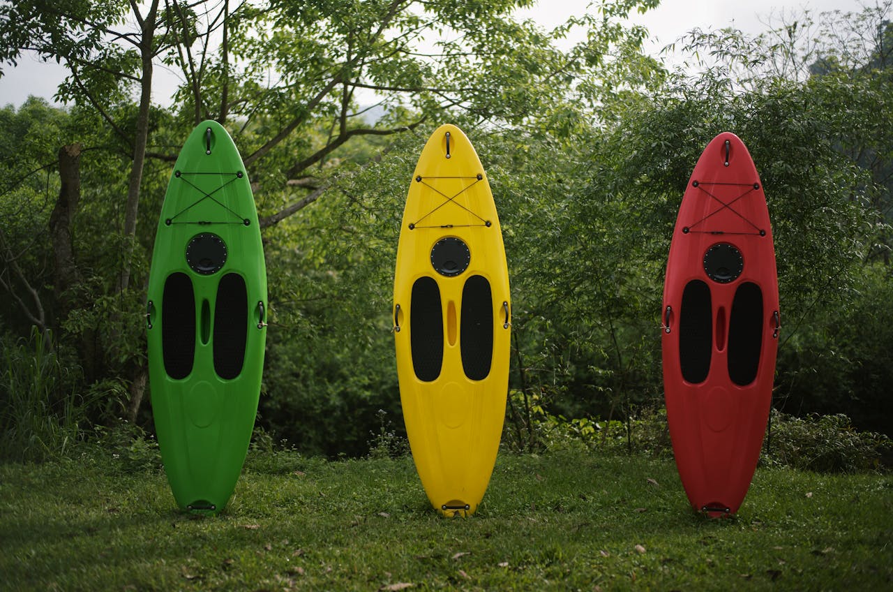 Colorful kayaks standing upright in a vibrant, green outdoor setting in Vietnam.